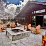 Lodge_FirePit-150x150 A stone patio with wooden Adirondack chairs