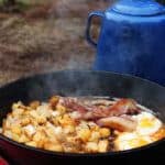 Sizzling bacon and potatoes in skillet