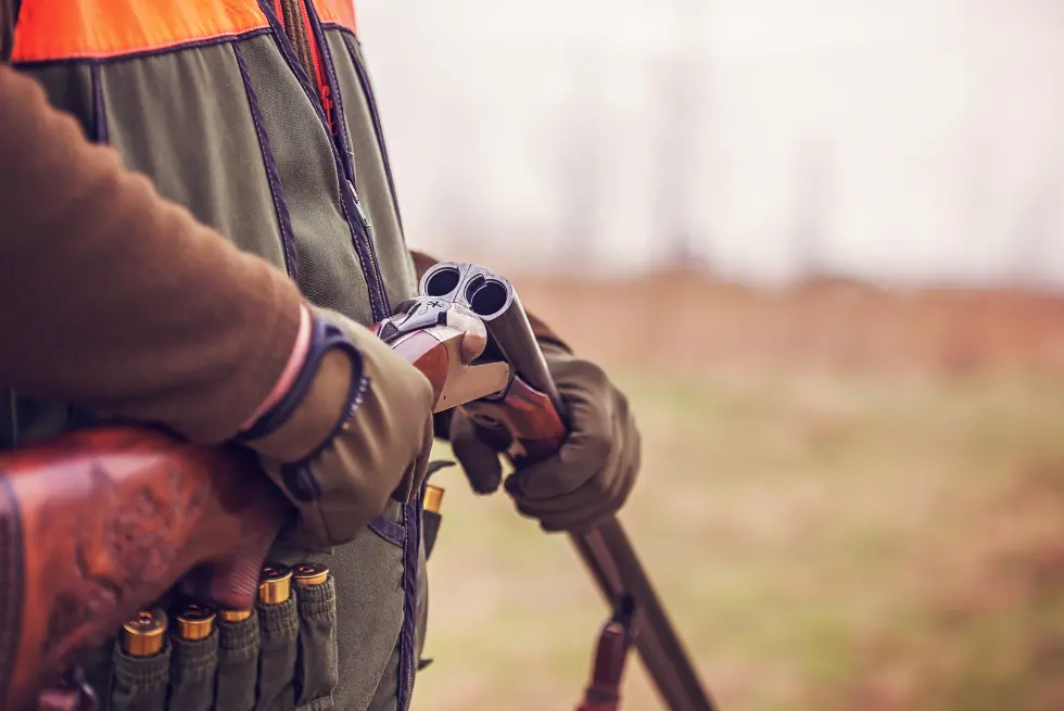 A hunter reloads his shotgun
