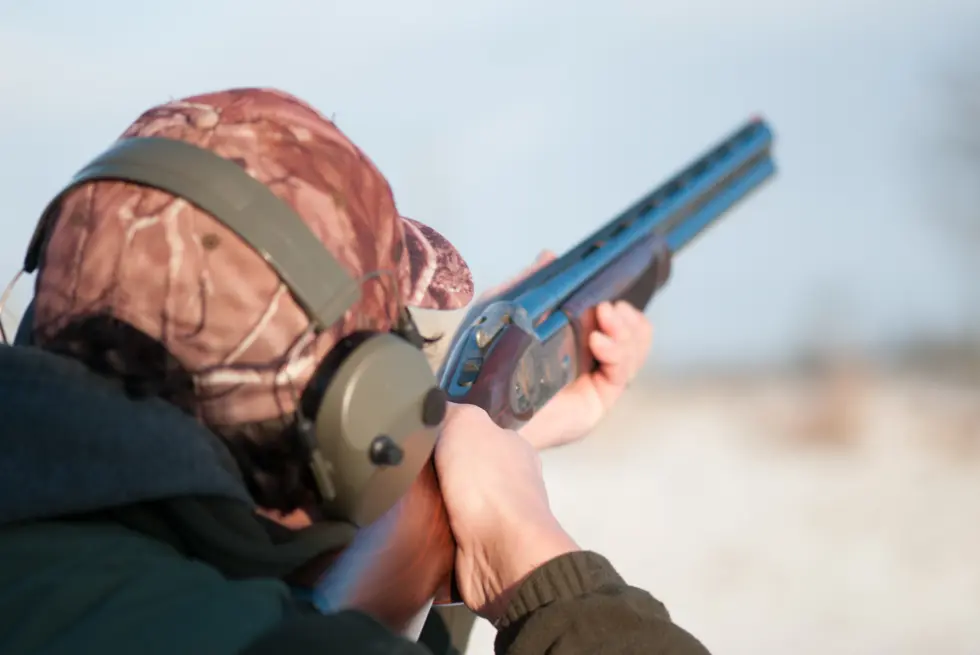 A shooter tracks a clay pigeon